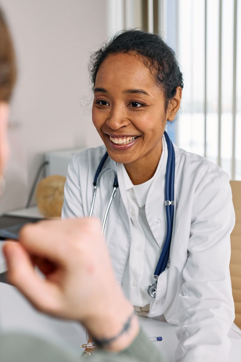 A doctor talking calmly with a patient in a bright consulting room